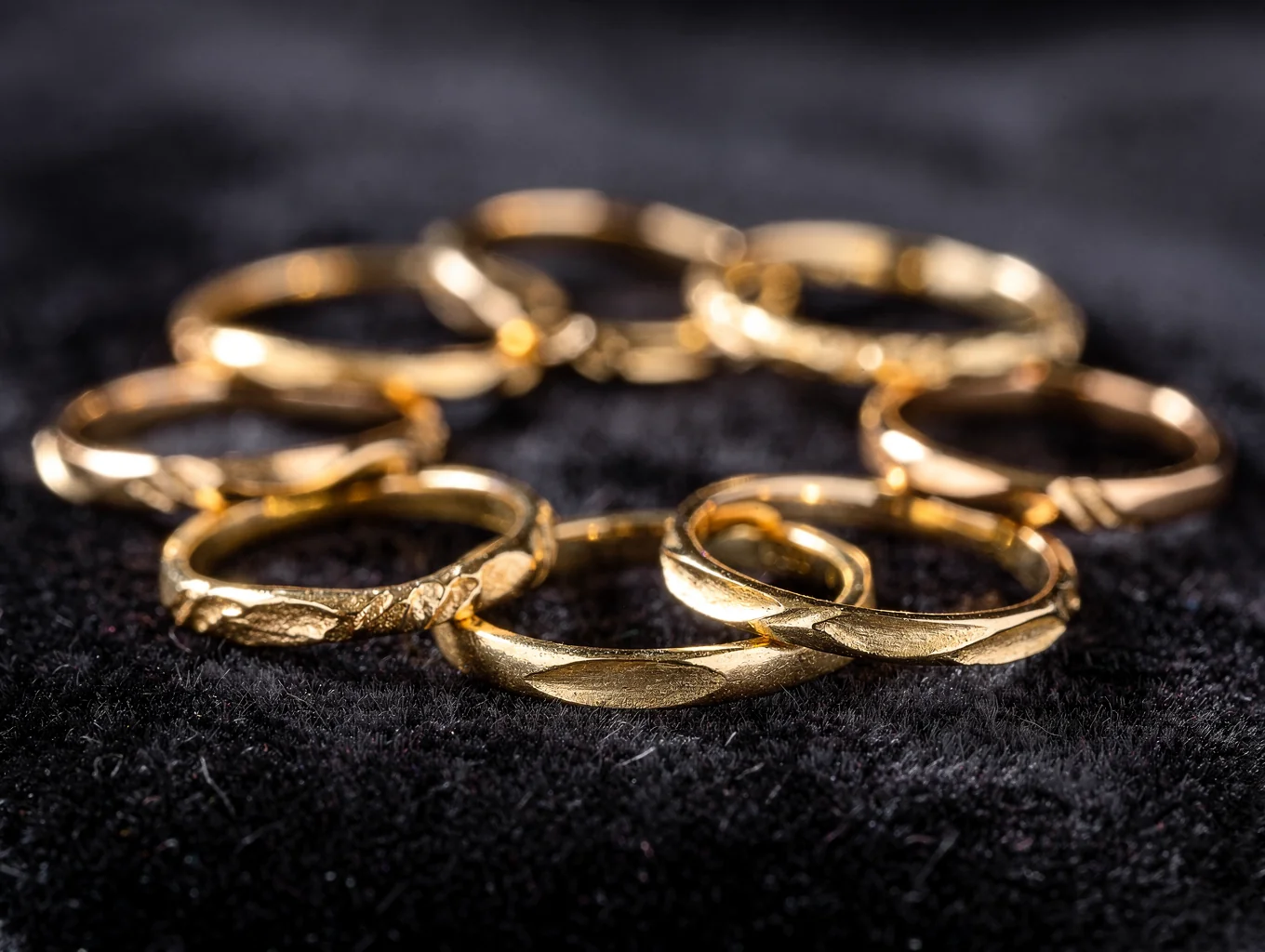Handcrafted sterling silver signet rings with hammered texture on an oxidized slate plinth
